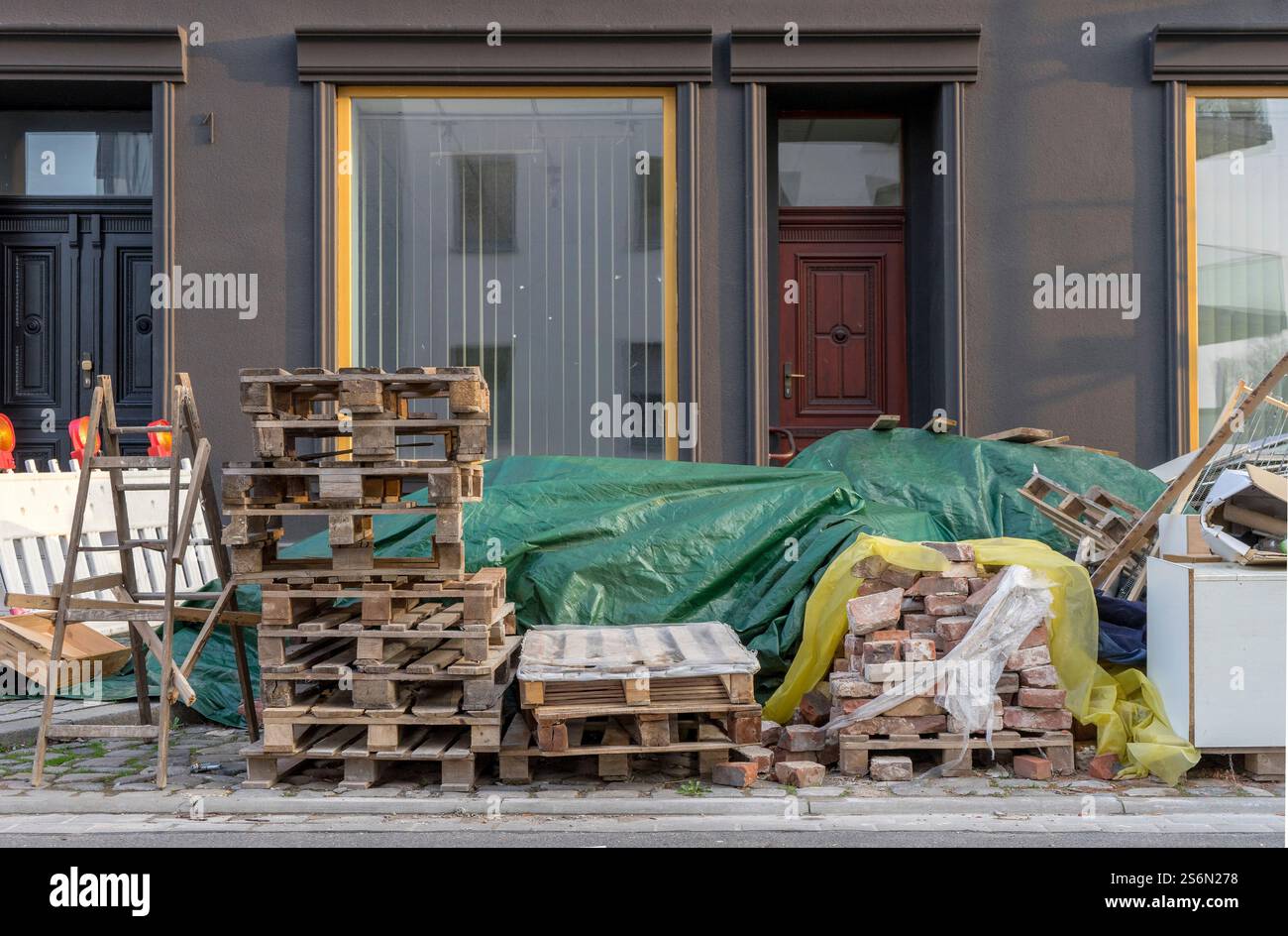 Matériaux de construction, échelle en bois, palettes Euro et déchets encombrants au bord de la route Banque D'Images