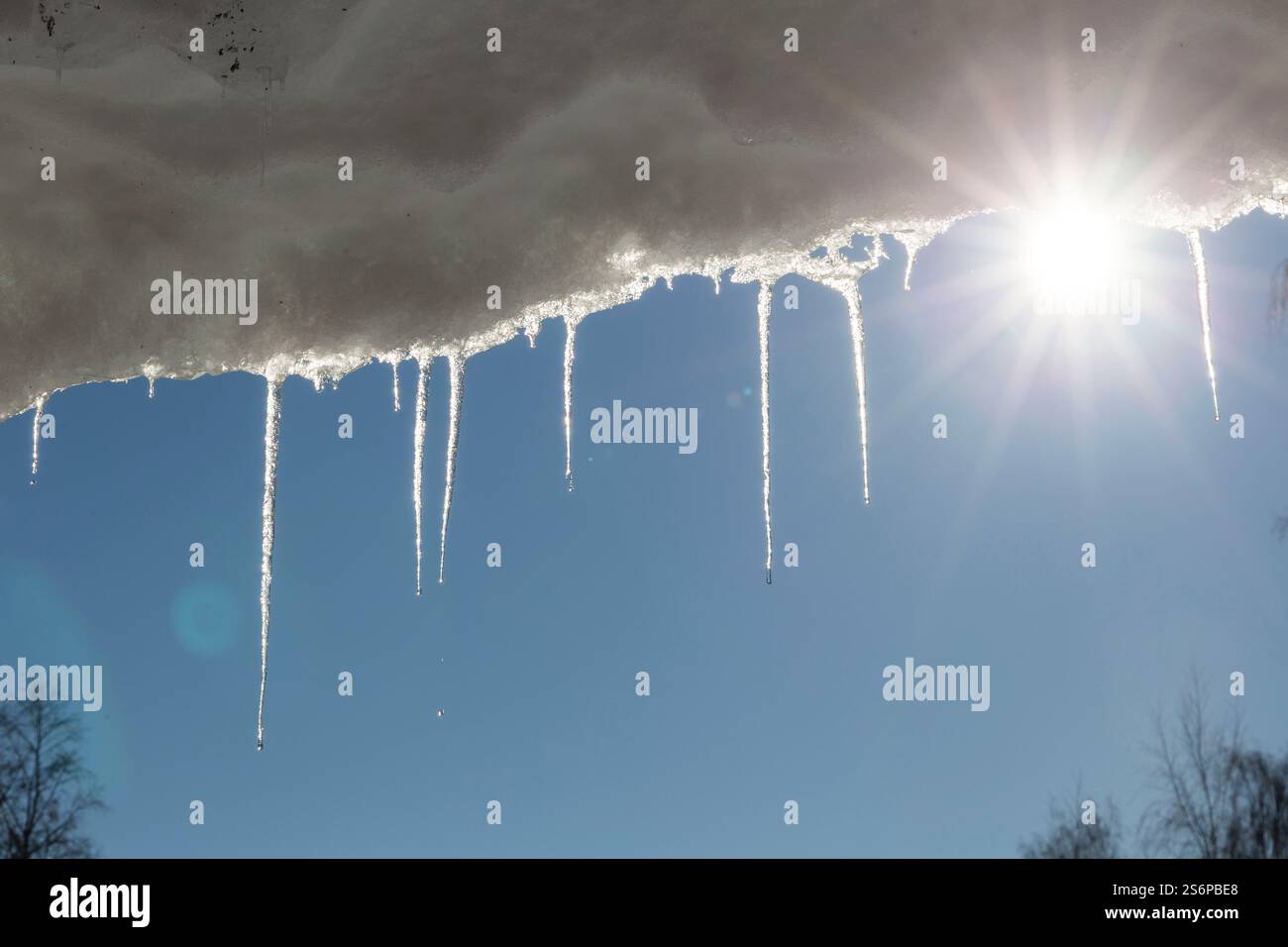 Glaçons fondants lumineux avec le ciel bleu et le soleil en arrière-plan. Printemps avec glace dégelante Banque D'Images