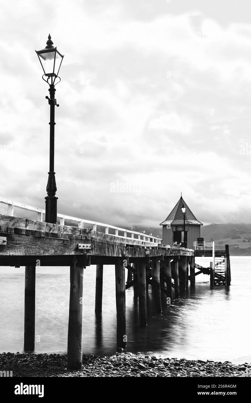 La jetée historique en bois de Daly's Wharf à Akaroa, sur l'île du Sud de Nouvelle-Zélande, est un motif photo populaire et un point de repère dans la petite ville. Banque D'Images