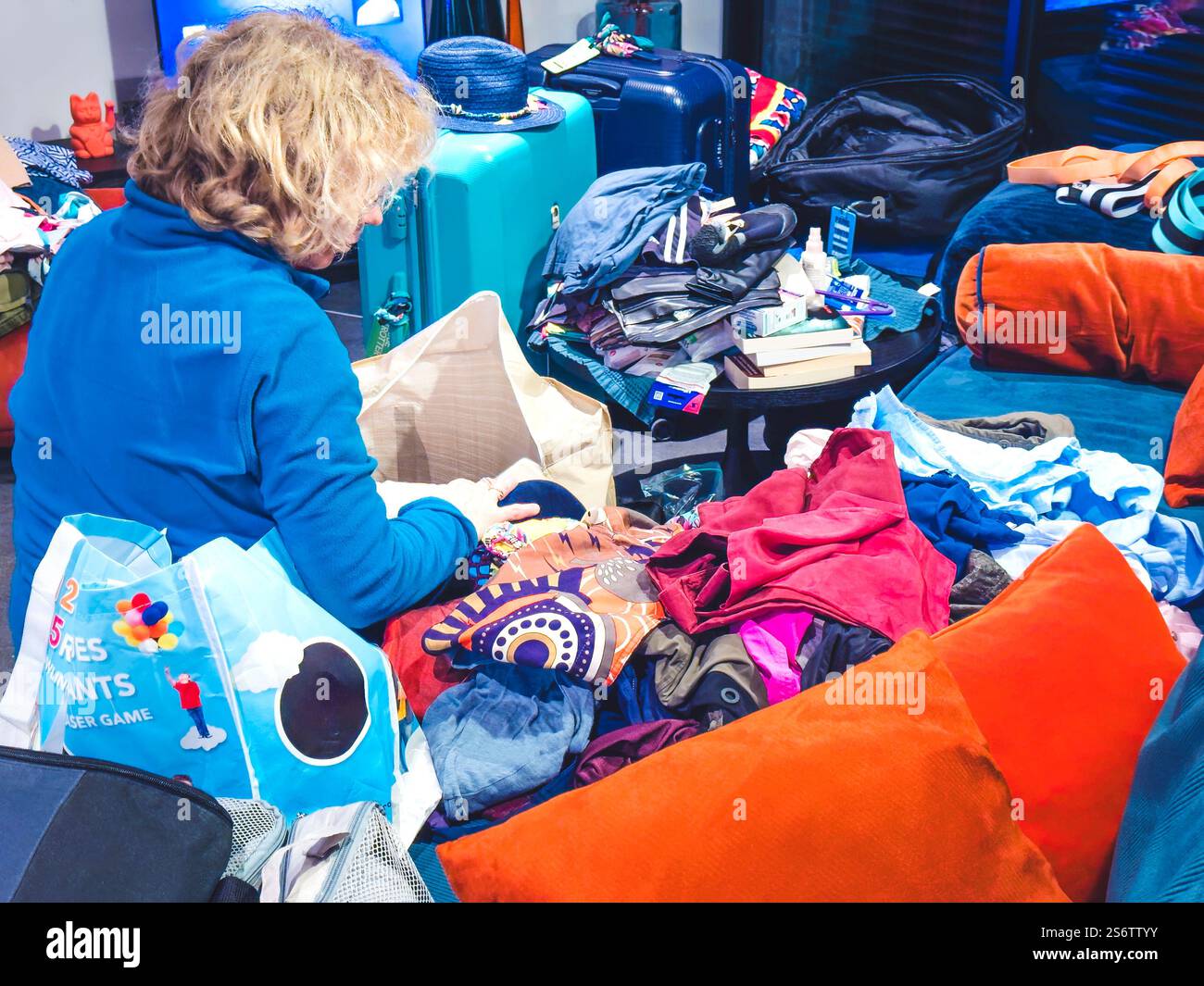 Femme blonde dans son salon préparant ses vacances Banque D'Images
