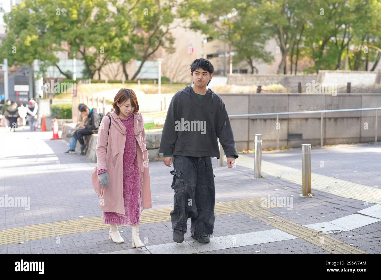 Un homme et une femme japonais dans la vingtaine marchent sur une voie publique à Sakae, dans le quartier de Naka, dans la ville de Nagoya, dans la préfecture d'Aichi. Banque D'Images