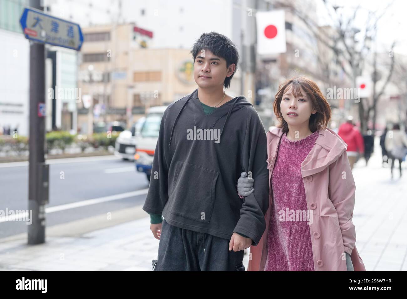 Un homme et une femme japonais dans la vingtaine marchent sur une voie publique à Sakae, dans le quartier de Naka, dans la ville de Nagoya, dans la préfecture d'Aichi. Banque D'Images