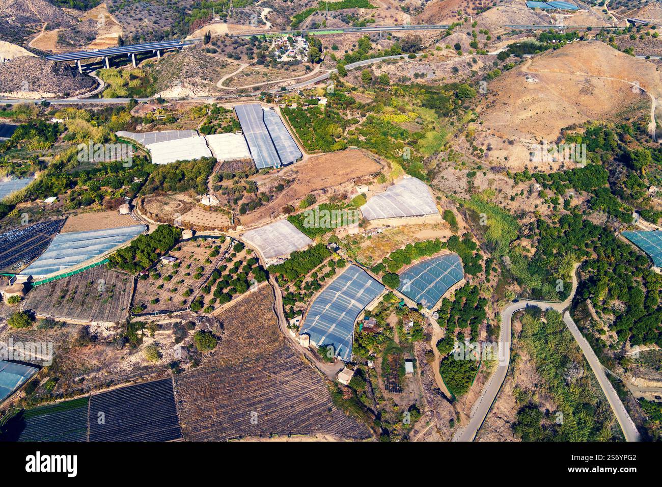 Vue de dessus des serres dans une zone montagneuse. Maro, Malaga, Espagne. Le Viaduc Manantial sur le coin supérieur gauche Banque D'Images