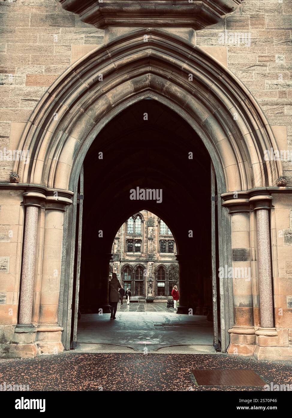 Une grande arche gothique mène au cœur de l'Université de Glasgow, invitant à l'exploration. Banque D'Images
