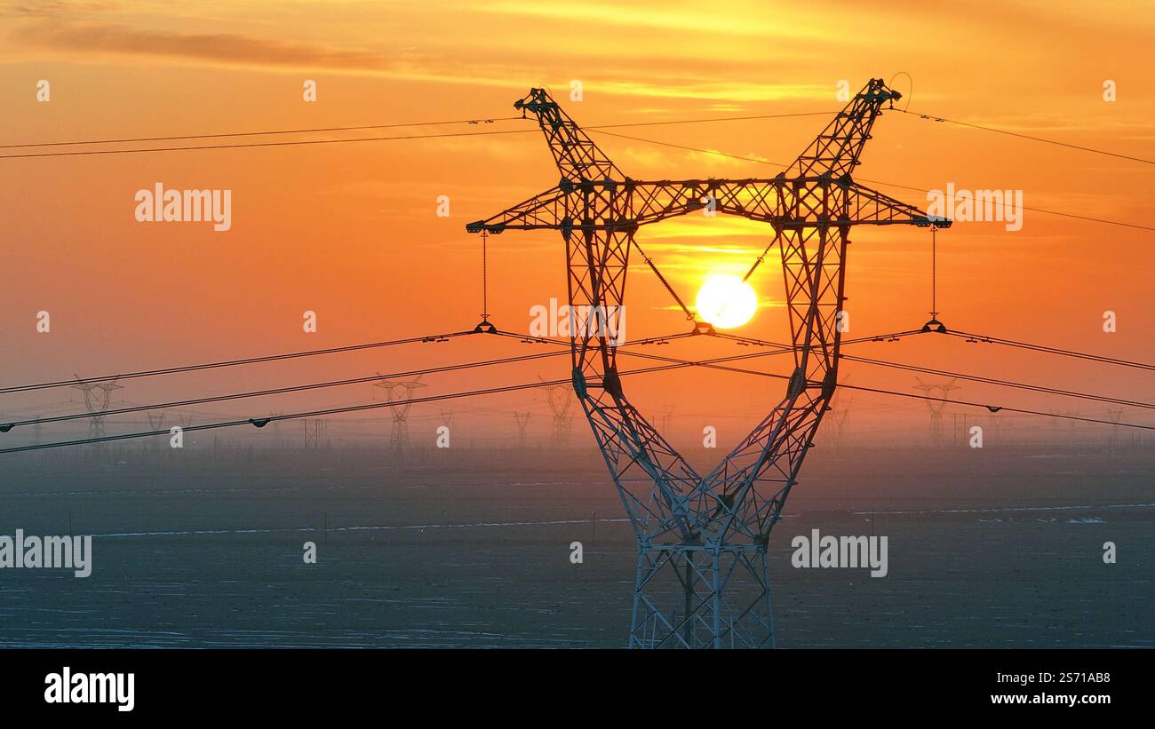 HAMI, CHINE - 18 JANVIER 2025 - la tour de puissance Ouest-est de transmission d'électricité du Hami Gobi est vue au coucher du soleil à Hami, province du Xinjiang, Chi Banque D'Images