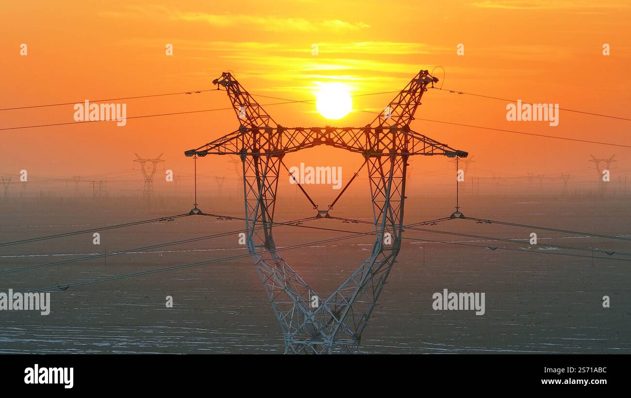 HAMI, CHINE - 18 JANVIER 2025 - la tour de puissance Ouest-est de transmission d'électricité du Hami Gobi est vue au coucher du soleil à Hami, province du Xinjiang, Chi Banque D'Images