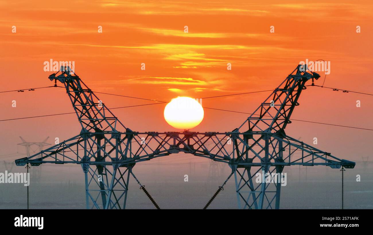 HAMI, CHINE - 18 JANVIER 2025 - la tour de puissance Ouest-est de transmission d'électricité du Hami Gobi est vue au coucher du soleil à Hami, province du Xinjiang, Chi Banque D'Images