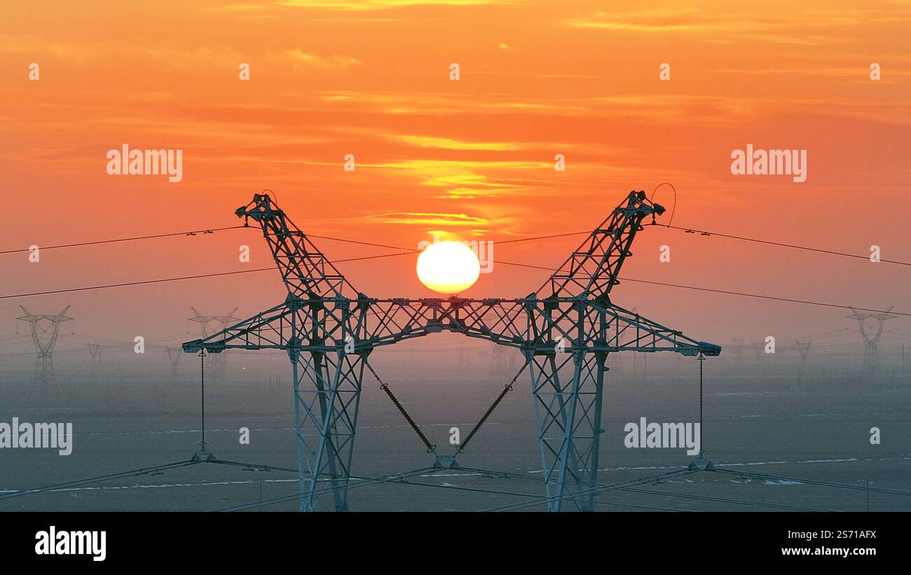 HAMI, CHINE - 18 JANVIER 2025 - la tour de puissance Ouest-est de transmission d'électricité du Hami Gobi est vue au coucher du soleil à Hami, province du Xinjiang, Chi Banque D'Images