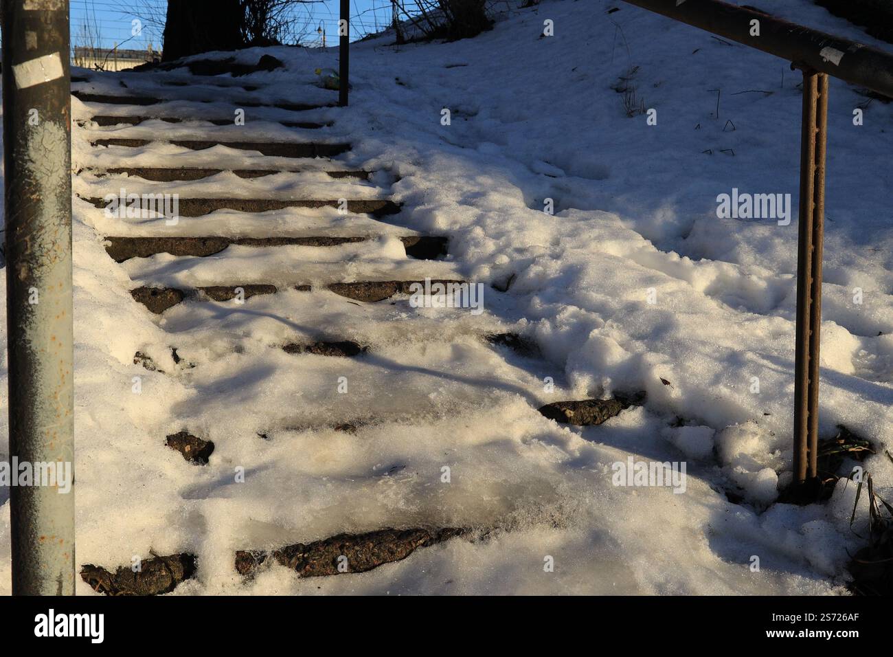 Un escalier extérieur menant vers le haut, couvert de neige et éclairé par le soleil et la neige dérive sur le côté Banque D'Images
