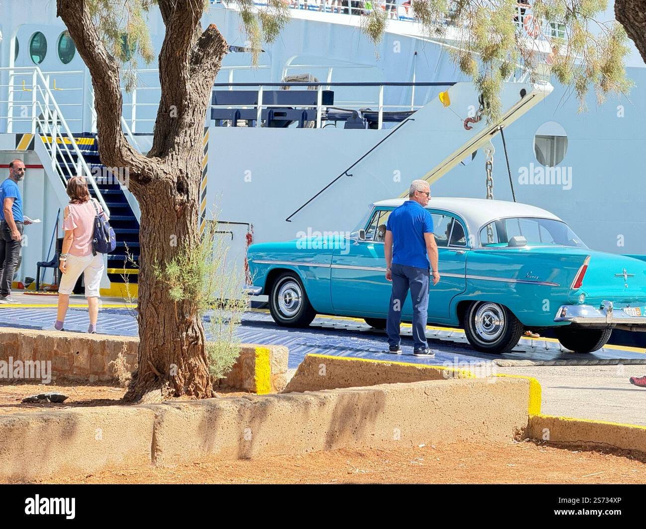 Voiture vintage allant au 21ème rassemblement de voitures classiques d'été à Istiea Aidipsos - les gens prêts à monter à bord du navire - le tronc d'un arbre au milieu Banque D'Images