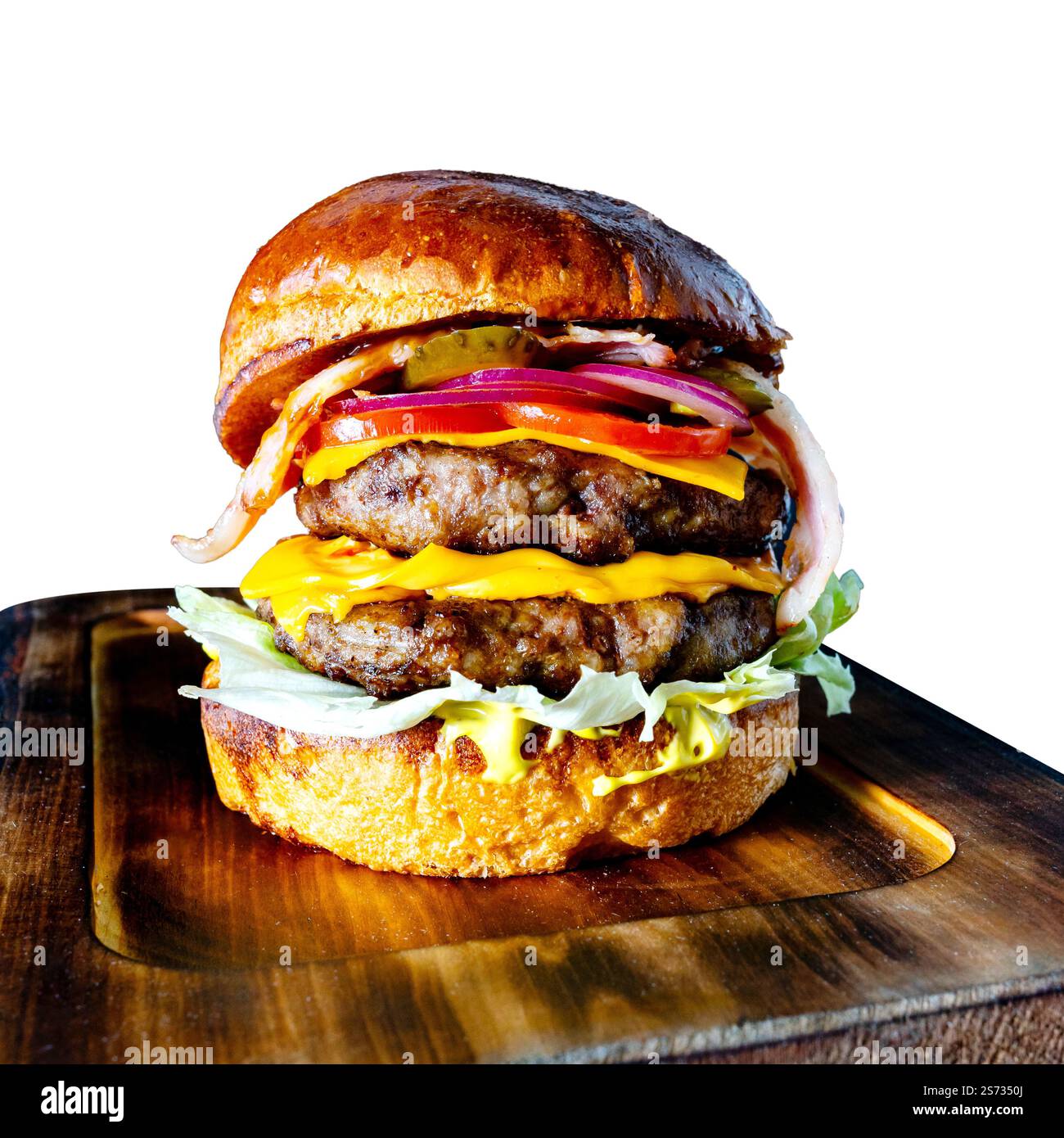 Un délicieux cheeseburger double est soigneusement disposé sur une planche de bois. Le hamburger comprend deux galettes de bœuf, du fromage cheddar, de la laitue, de la tomate, de l'oignon, Banque D'Images