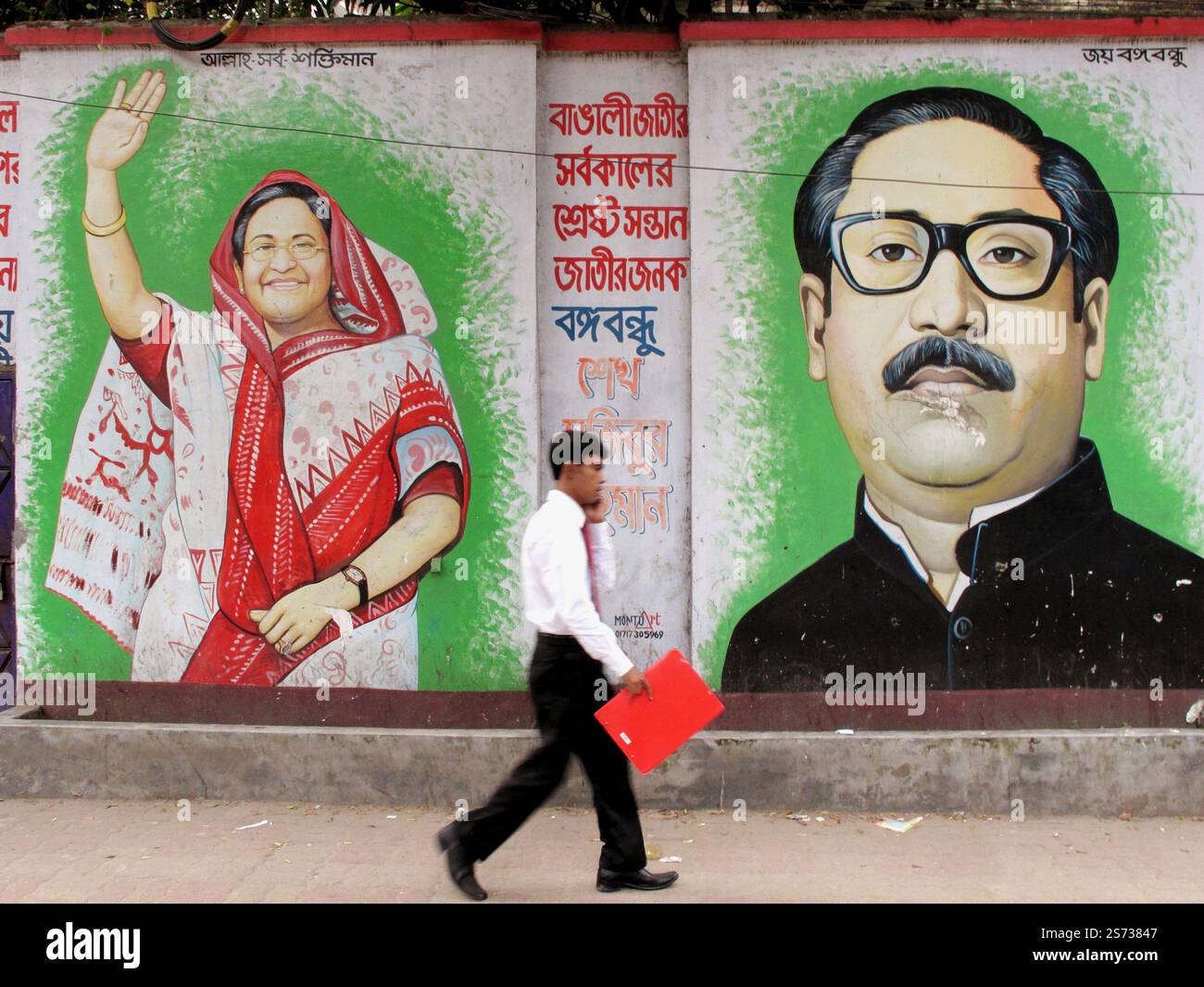 Peintures murales de Sheikh Hasina et Sheikh Mujibur Rahman à Dhaka, au Bangladesh, alors qu'un passant passe par là. Banque D'Images