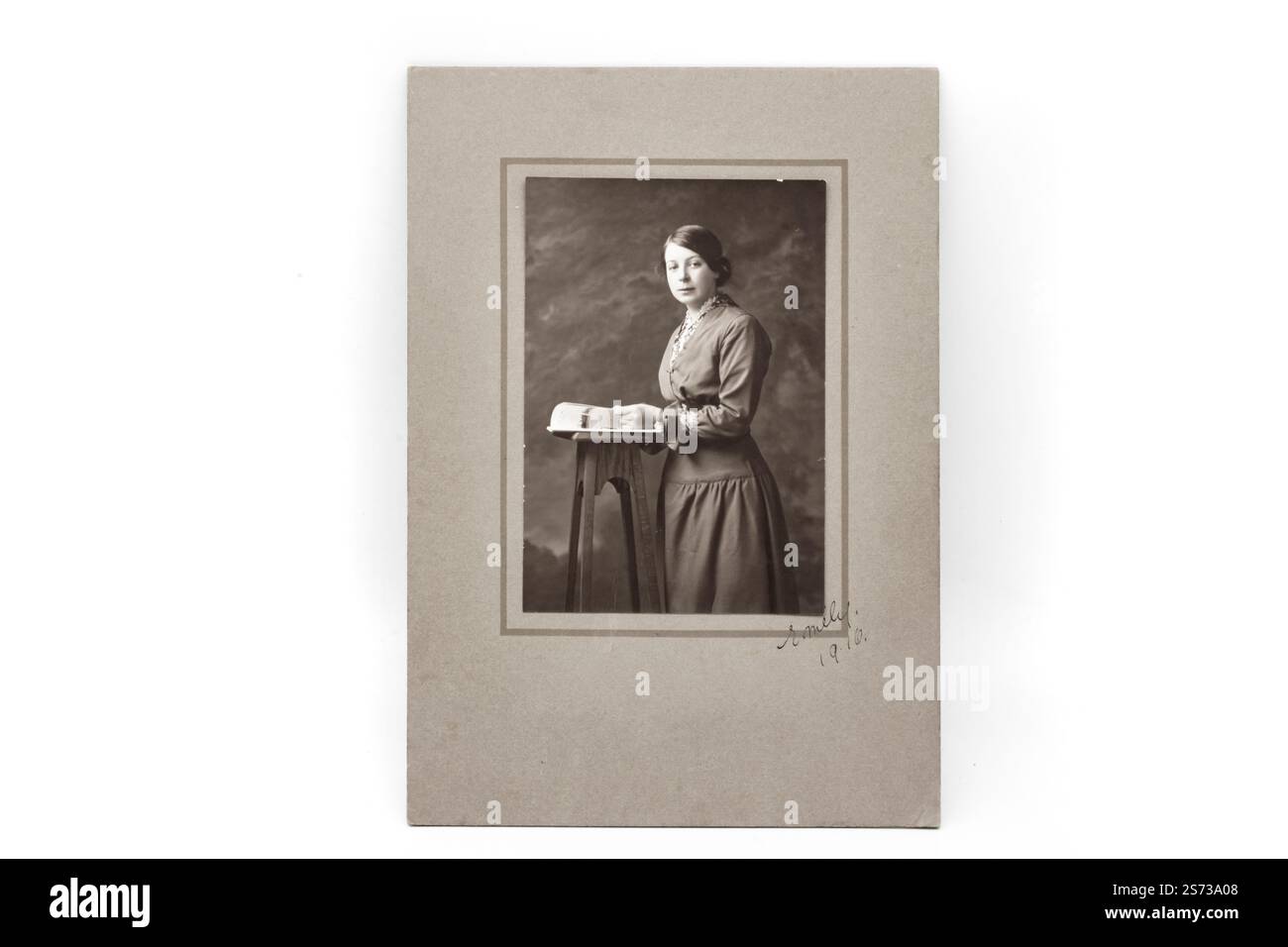 vieux vintage édouardien noir et blanc sépia posé photographie de studio d'une jeune femme avec des supports de cartes Banque D'Images