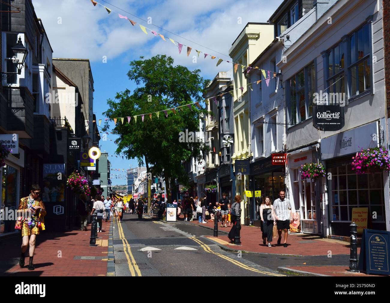 Les gens marchant dans une rue avec des décorations festives de banderole. Brighton, Angleterre, Royaume-Uni Banque D'Images