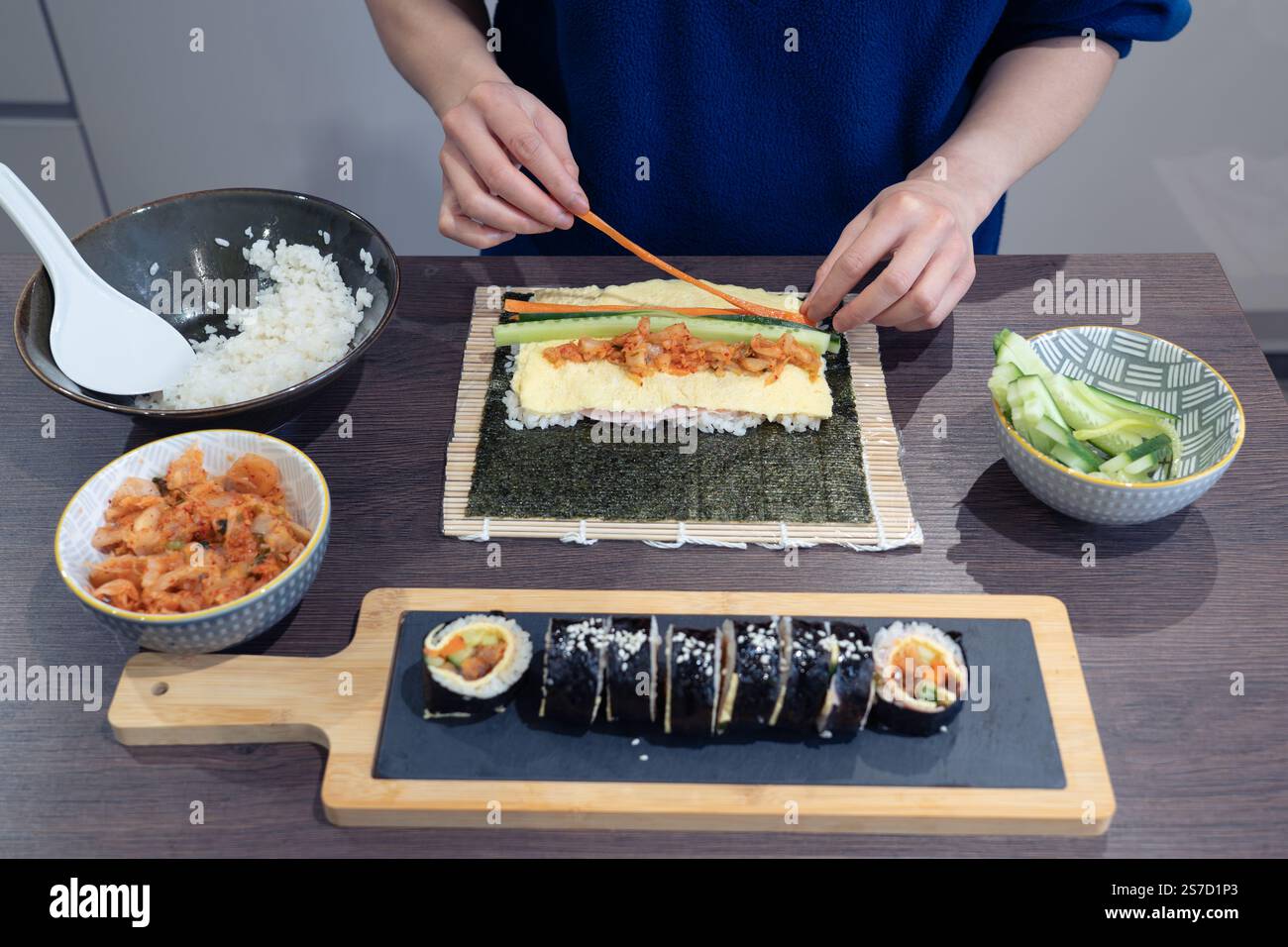 Femme asiatique préparant la garniture de légumes pour Kimchi Gimbap - un plat populaire sud-coréen, Royaume-Uni. Concept - cuisine coréenne, cuisine asiatique Banque D'Images