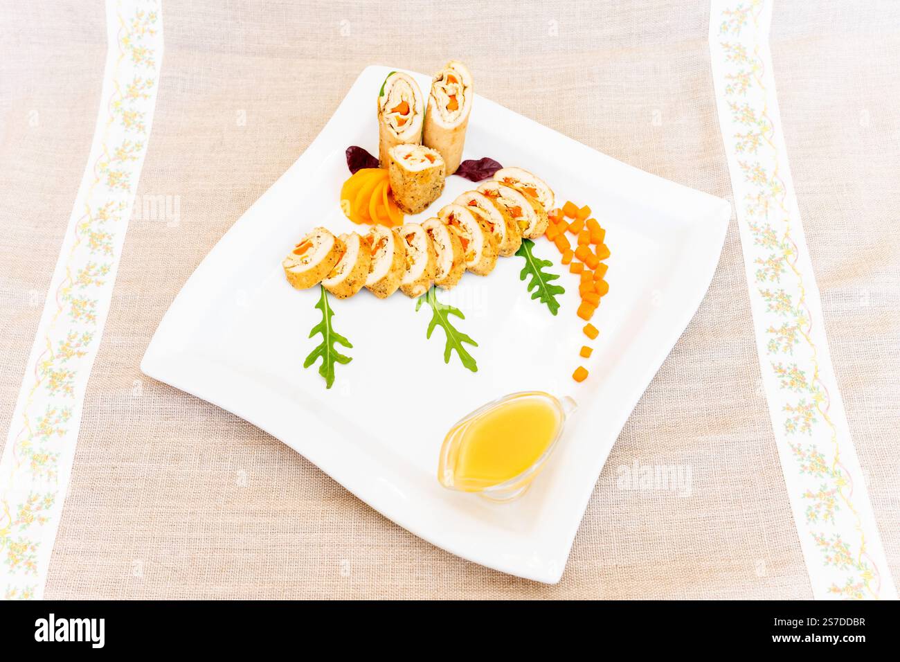 Un plateau de sushis magnifiquement arrangé avec divers rouleaux, des légumes colorés et un filet de sauce. La présentation est attrayante et marquante Banque D'Images