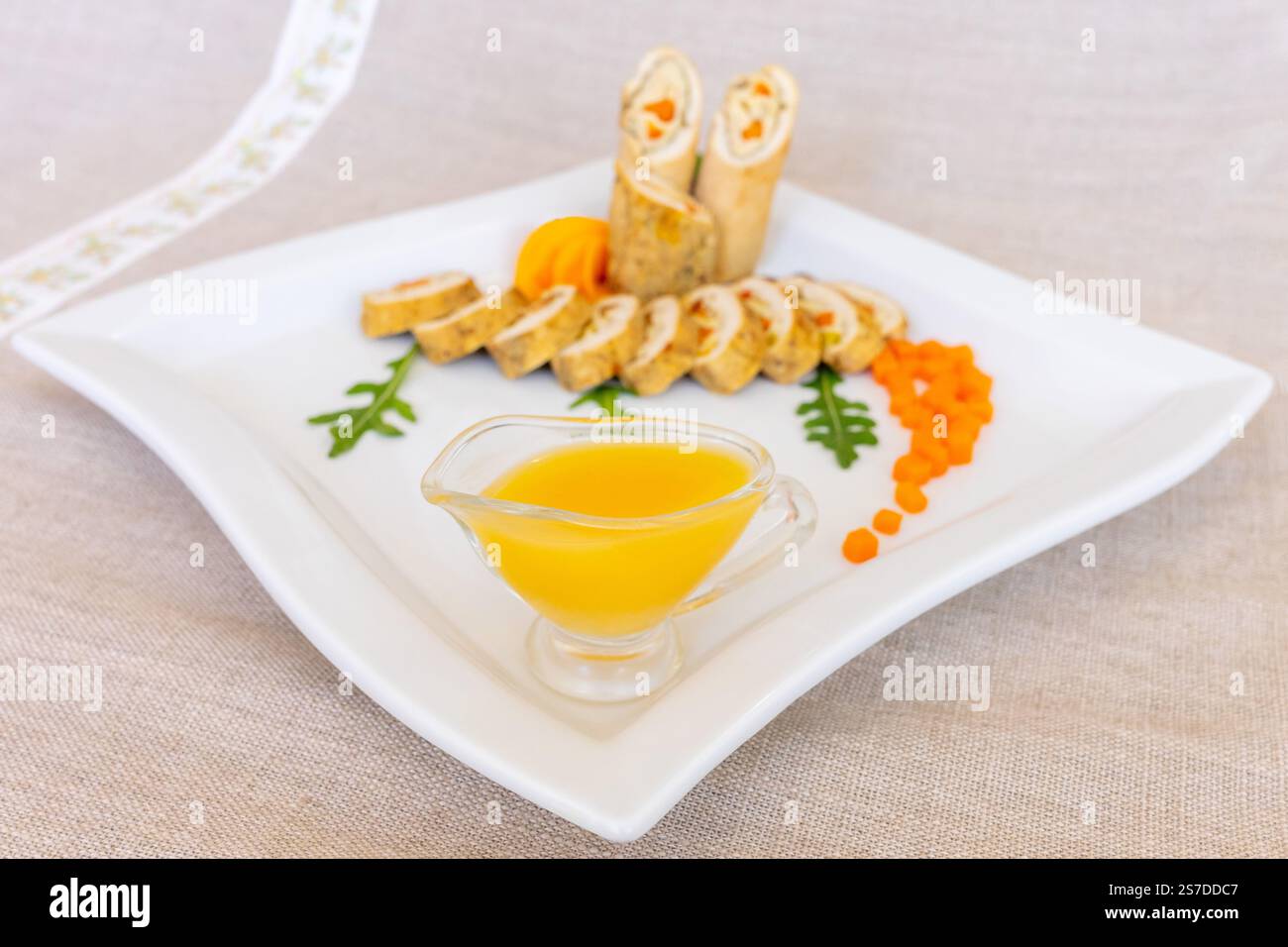 Cette présentation gourmande met en valeur des tranches de poulet roulées disposées magnifiquement sur une assiette blanche. Banque D'Images