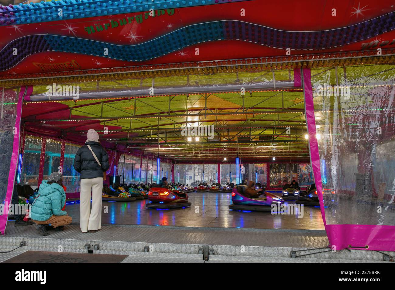 Iasi, Roumanie - 26 décembre 2024 : les gens visitent autodrome avec des voitures pare-chocs électriques colorées ou des voitures dodgem dans l'attraction au marché de Noël en c. Banque D'Images