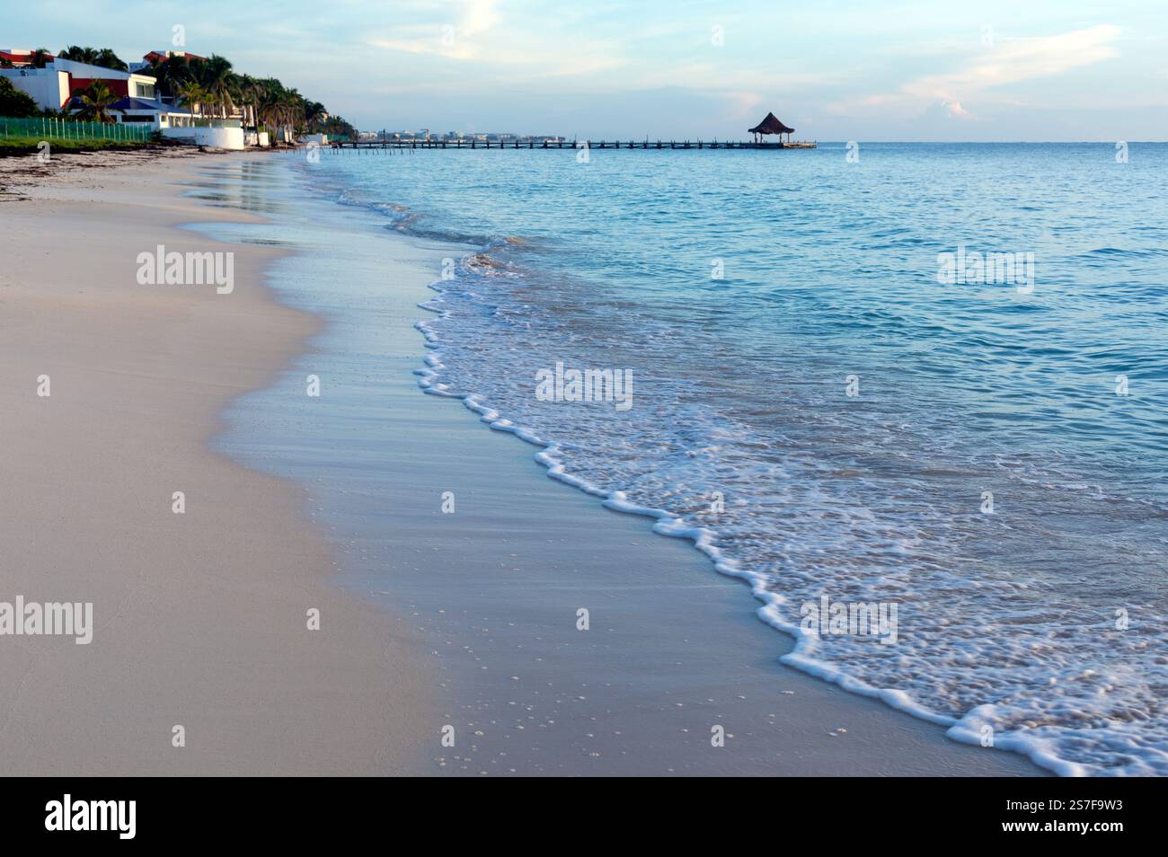Mexique, Puerto Morelos, plage avec surf et une jetée avec un palapa Banque D'Images