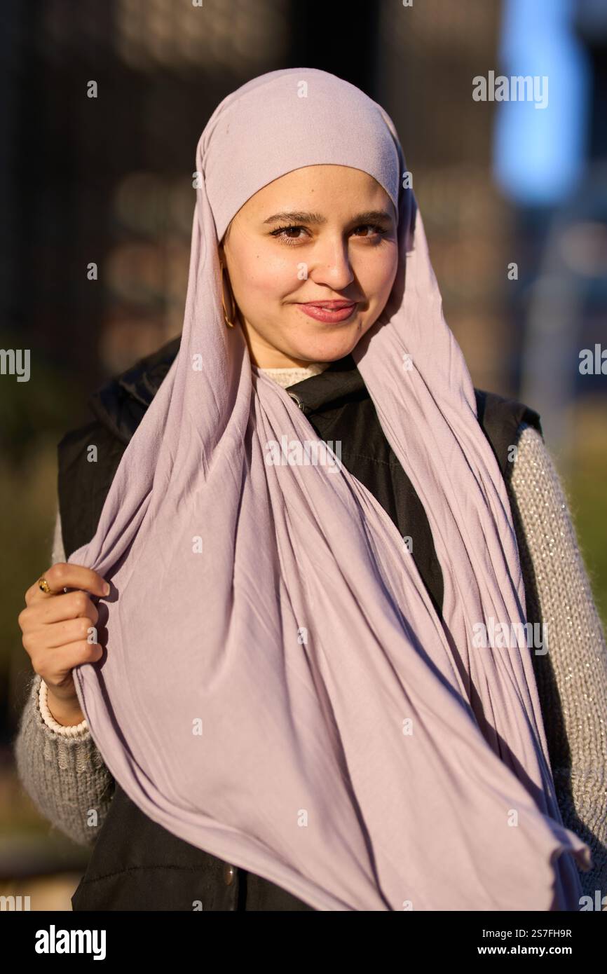 Jeune femme musulmane portant le hijab souriant dehors Banque D'Images