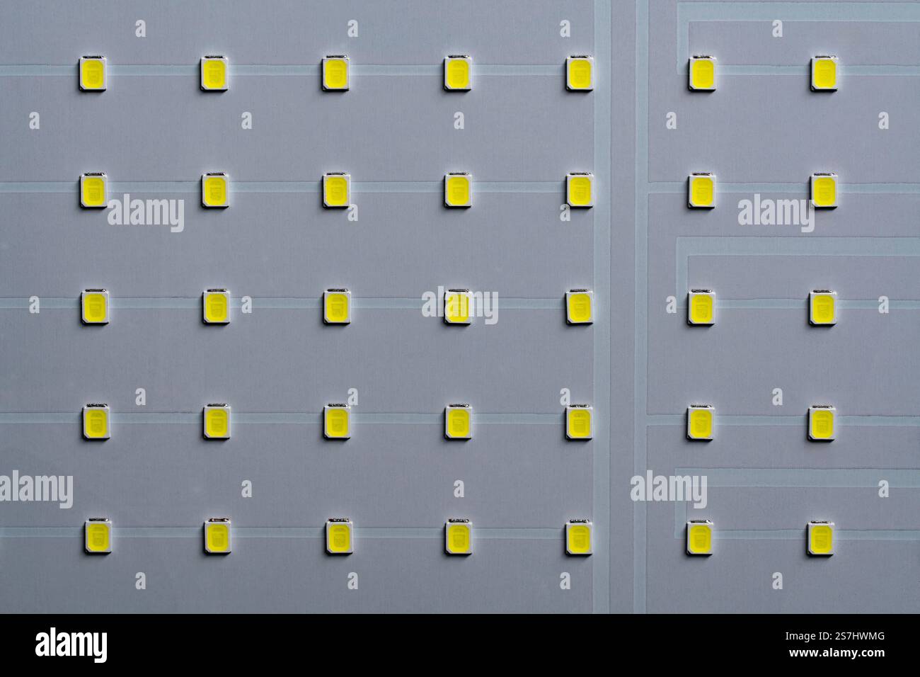 Panneau LED blanc avec lumière jaune sur fond, vue de dessus, gros plan Banque D'Images