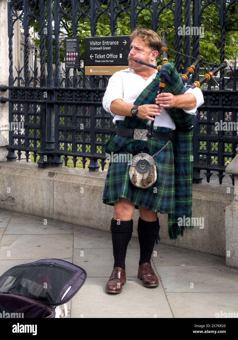 Londres, Royaume-Uni - 29 juin 2023 : artiste de rue habillé de vêtements authentiques écossais se produisant avec cornemuse dans la rue de Londres. Banque D'Images