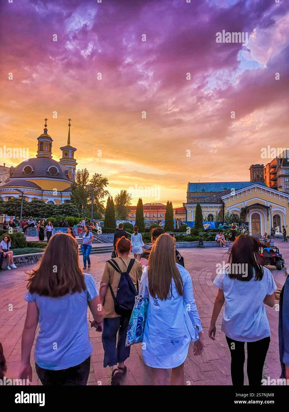 Trois jeunes femmes marchent dans la région, sous un riche coucher de soleil à Kiev, en Ukraine. Banque D'Images