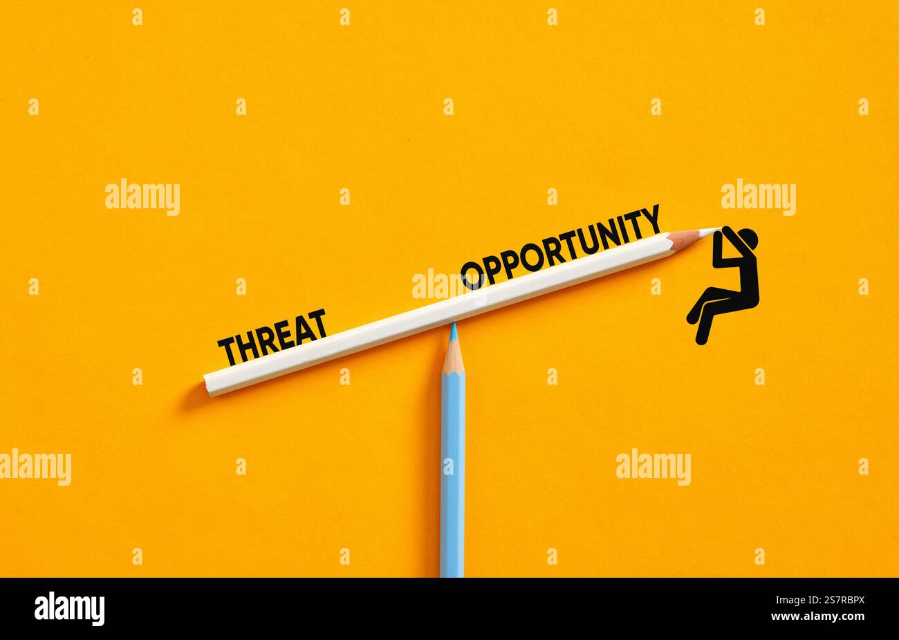 Image conceptuelle de l'homme d'affaires utilisant la balançoire faite de crayons pour équilibrer les menaces et les opportunités d'affaires et de marché, sur fond jaune Banque D'Images