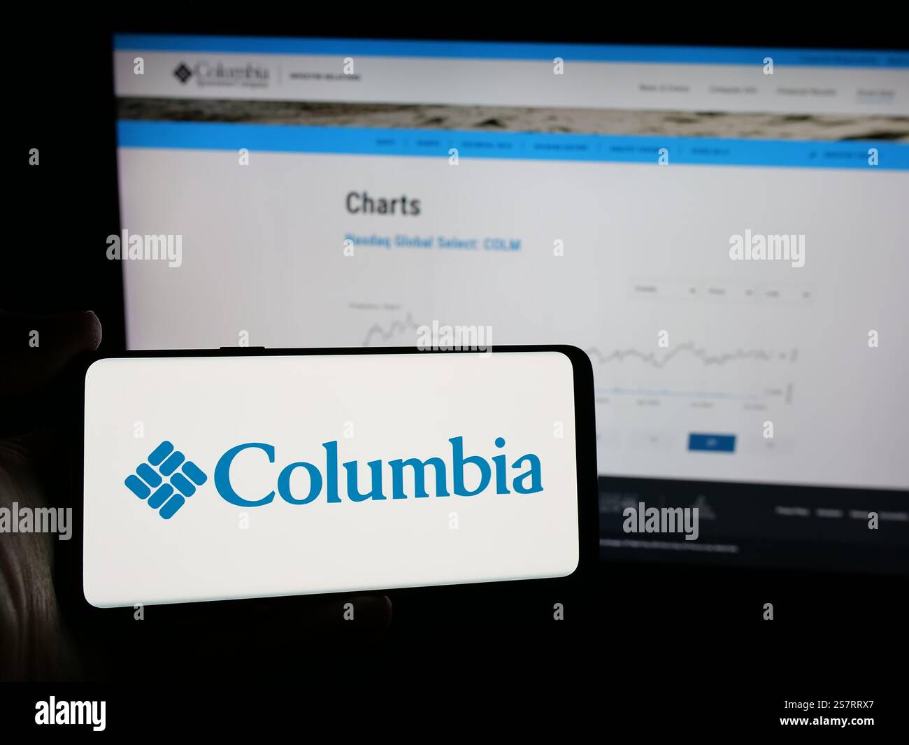 Dans cette illustration photo, une personne tient un smartphone avec le logo de l'entreprise américaine Columbia Sportswear Company sur l'écran devant le site Web. Banque D'Images