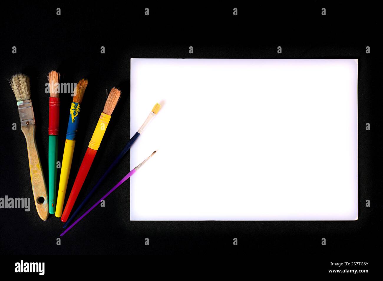 Fournitures d'art avec des pinceaux colorés et une toile blanche vierge, idéales pour les projets créatifs. Banque D'Images