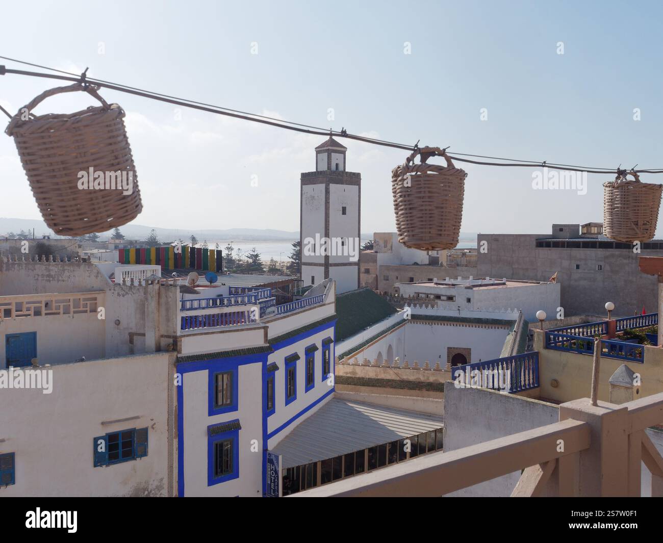 Vue depuis le balcon de la terrasse au sommet du restaurant Mega Loft vers la tour d'une mosquée dans la ville d'Essaouira avec la mer derrière, Maroc. 19 janvier 2025 Banque D'Images