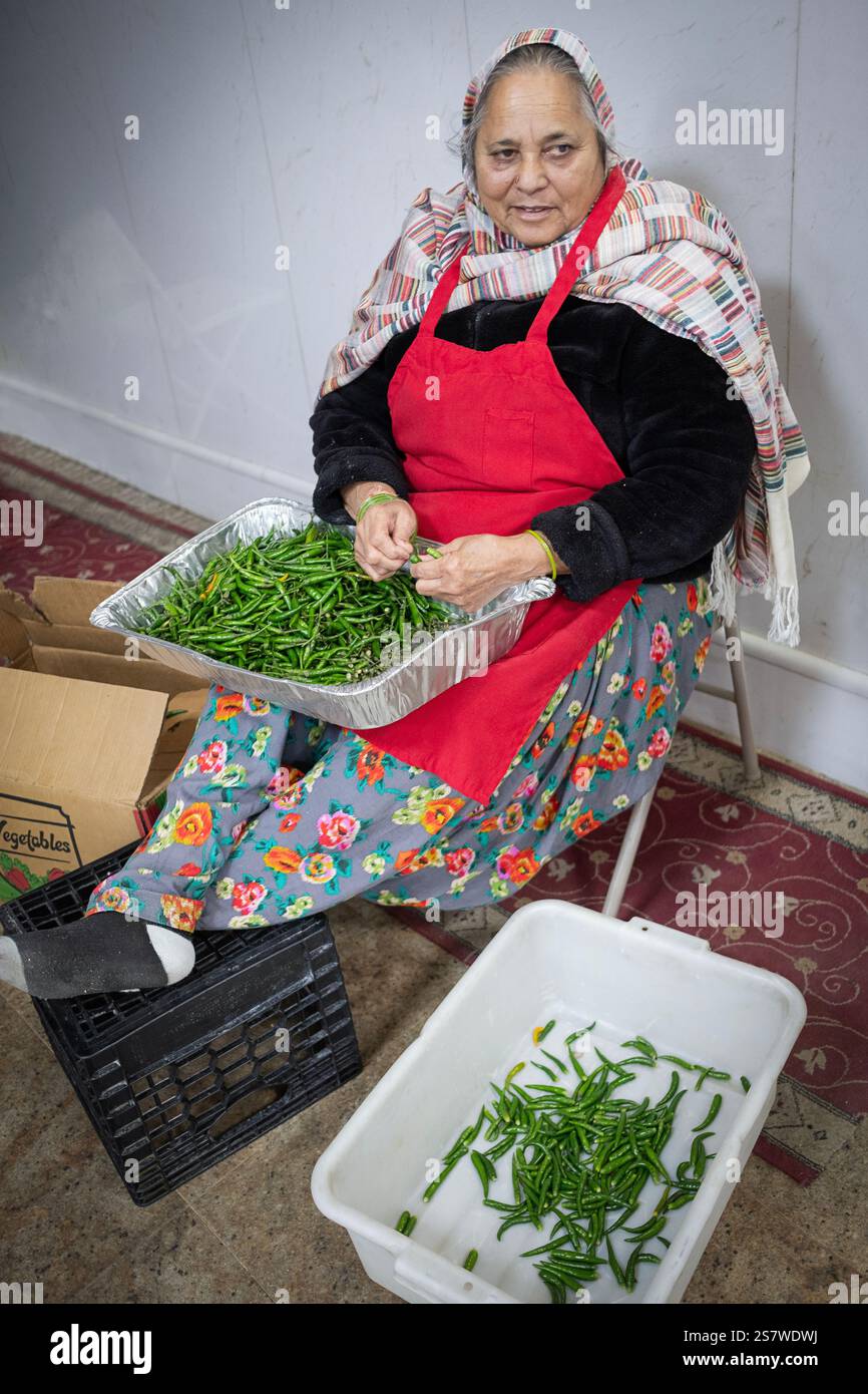 Une femme sikhe pieuse bénévole inn la cuisine langar prépare des haricots à ficelle pour les visiteurs du temple. À South Richmond Hill, Queens, New York. Banque D'Images