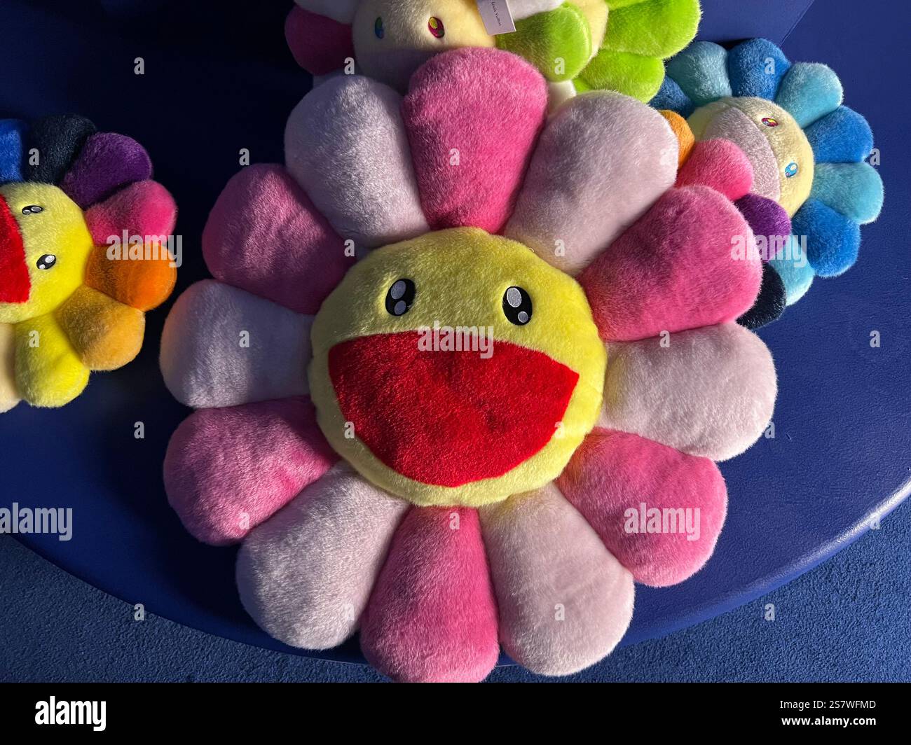 L'oreiller Happy Flowers de Takashi Murakami présente des marguerites aux couleurs vives avec des visages d'expression souriants. Articles coûteux en édition limitée. - Image de stock capturée avec un smartphone