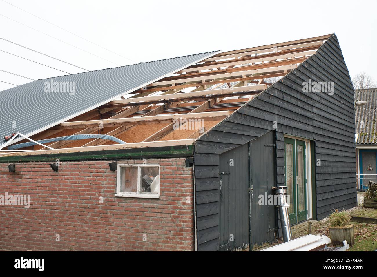 14 janvier 2025 - Hoogeveen, pays-Bas : un toit en tôle sur une ferme est remplacé par des panneaux en tôle sandwich isolés modernes, au milieu Banque D'Images