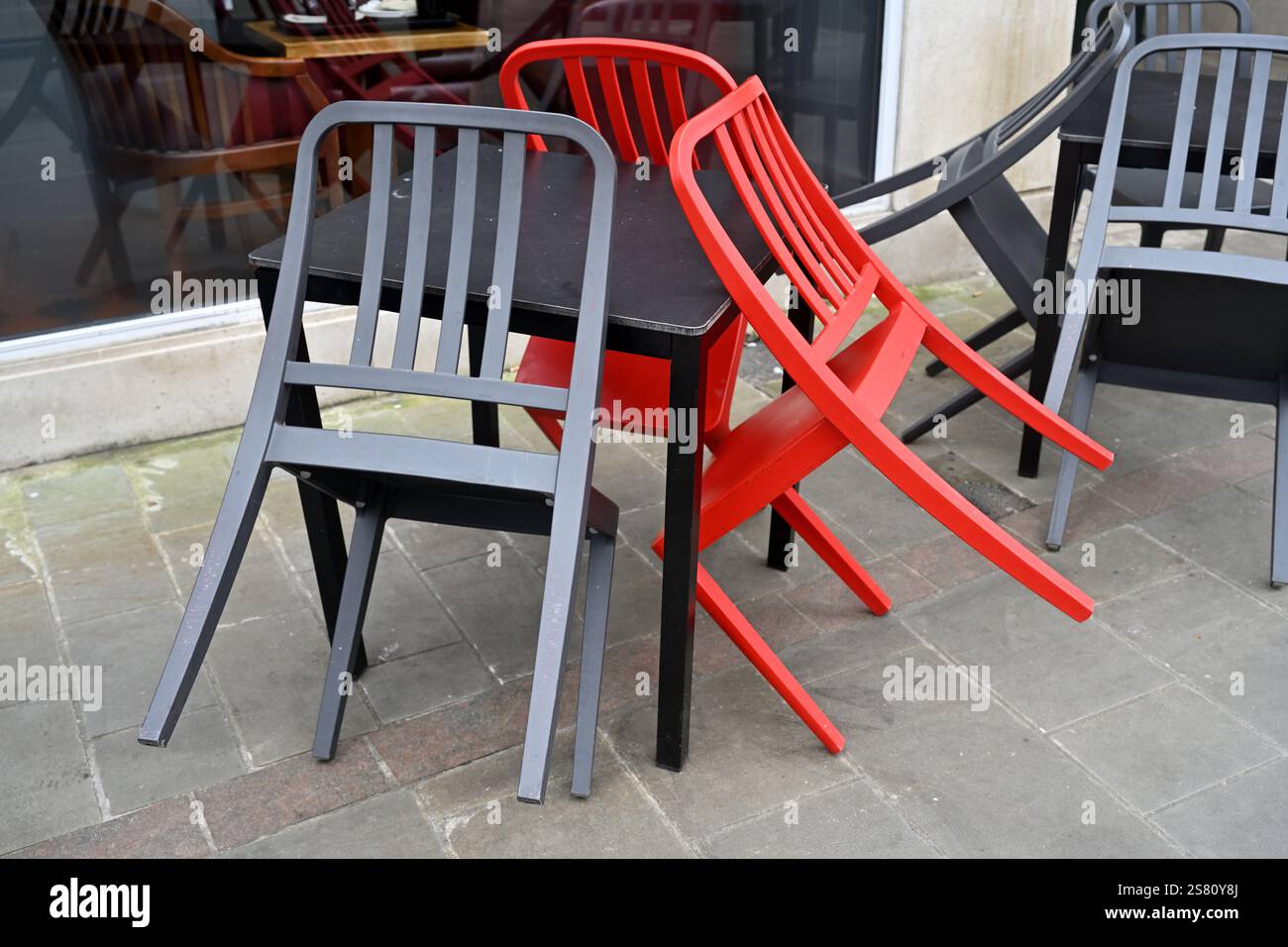 Chaises vides colorées appuyées contre la table Banque D'Images