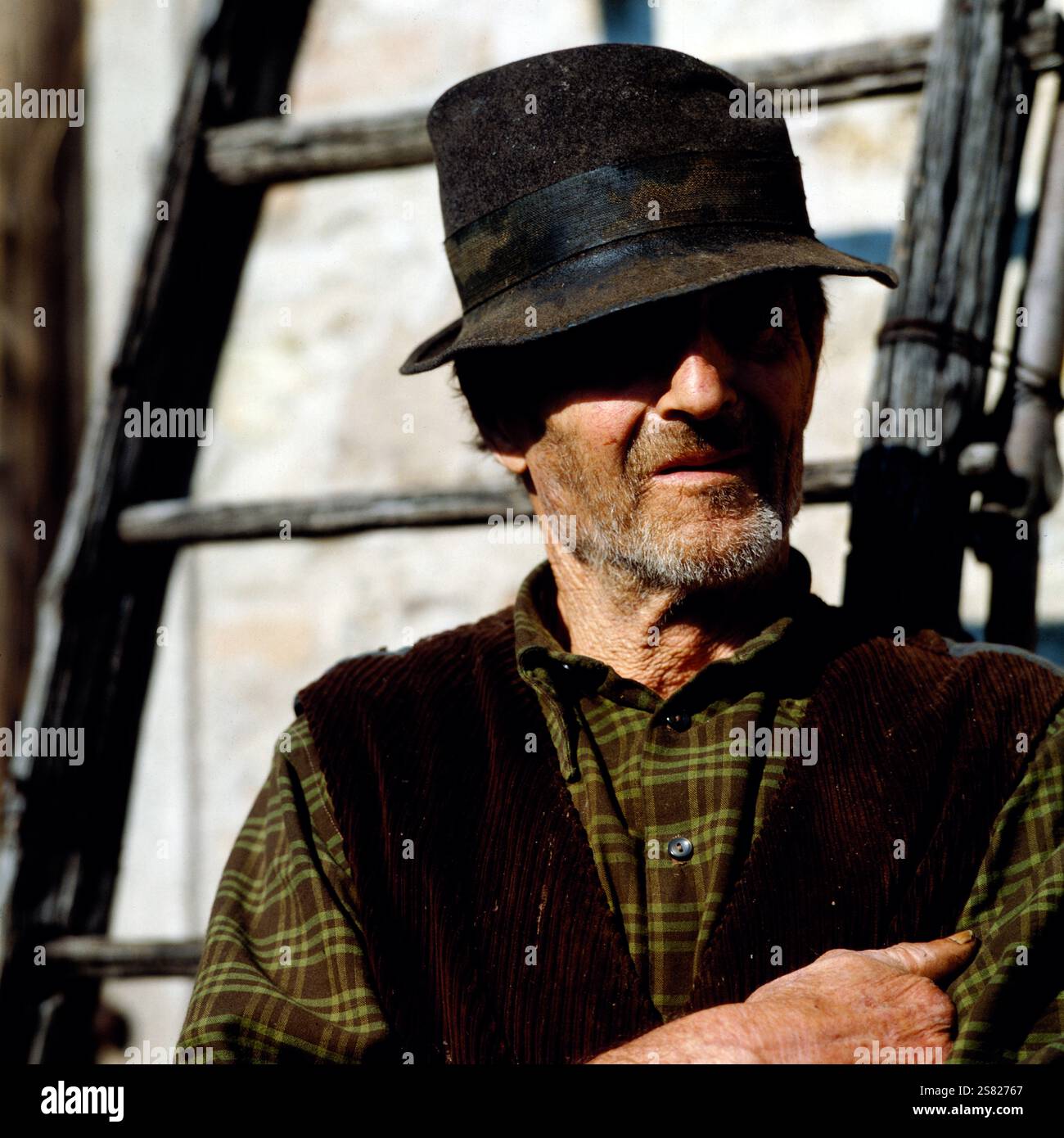 Porträt eines älteren Bauern, der einen Hut trägt und mit verschränkten Armen in Venetien, Italien, posiert, Italien um 1976. Banque D'Images