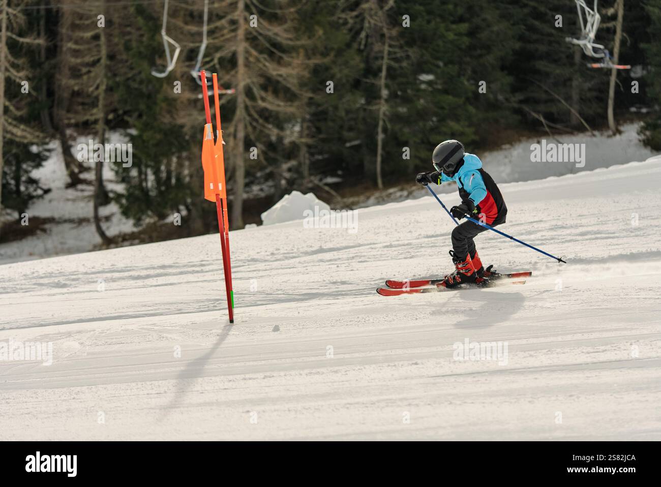 Groupe de personnes skiant dans les montagnes par une journée ensoleillée d'hiver. Cours de ski avec instructeurs locaux. Les enfants apprennent à skier avec un moniteur. Enfants Banque D'Images