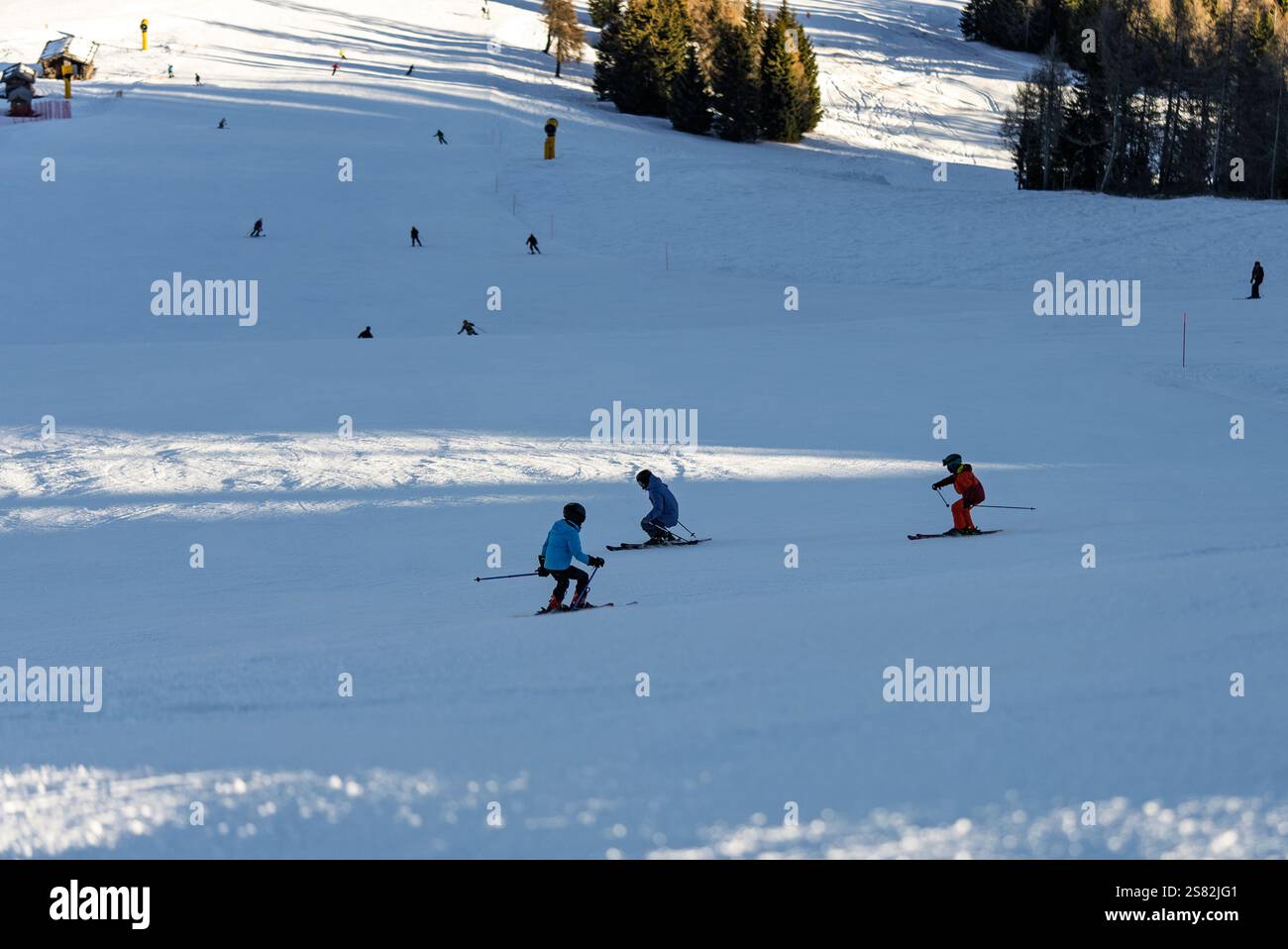 Groupe de personnes skiant dans les montagnes par une journée ensoleillée d'hiver. Cours de ski avec instructeurs locaux. Les enfants apprennent à skier avec un moniteur. Enfants Banque D'Images
