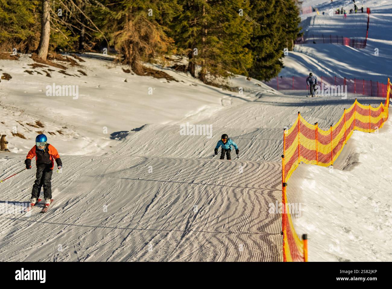 Groupe de personnes skiant dans les montagnes par une journée ensoleillée d'hiver. Cours de ski avec instructeurs locaux. Les enfants apprennent à skier avec un moniteur. Enfants Banque D'Images