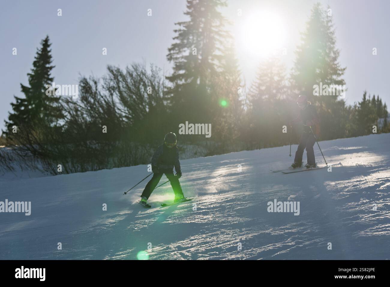Groupe de personnes skiant dans les montagnes par une journée ensoleillée d'hiver. Cours de ski avec instructeurs locaux. Les enfants apprennent à skier avec un moniteur. Enfants Banque D'Images