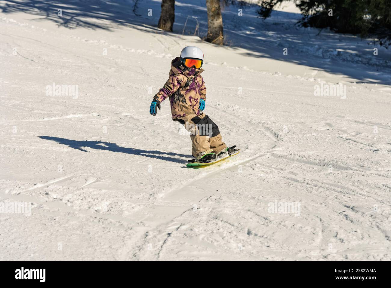 Groupe de personnes snowboard dans les montagnes par une journée ensoleillée d'hiver. Cours de snowboard avec instructeurs locaux. Les enfants apprennent à faire du snowboard avec un instruc Banque D'Images