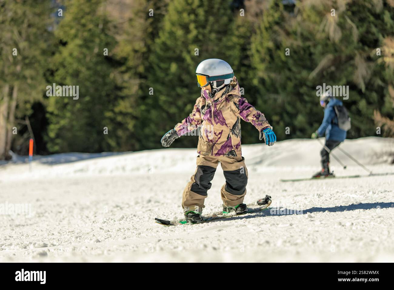 Groupe de personnes snowboard dans les montagnes par une journée ensoleillée d'hiver. Cours de snowboard avec instructeurs locaux. Les enfants apprennent à faire du snowboard avec un instruc Banque D'Images