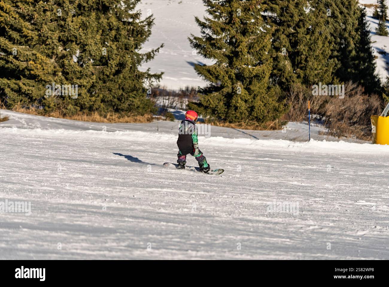Groupe de personnes snowboard dans les montagnes par une journée ensoleillée d'hiver. Cours de snowboard avec instructeurs locaux. Les enfants apprennent à faire du snowboard avec un instruc Banque D'Images