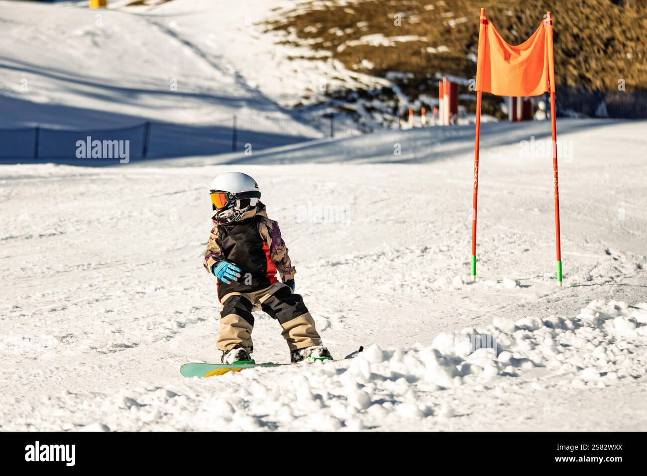Groupe de personnes snowboard dans les montagnes par une journée ensoleillée d'hiver. Cours de snowboard avec instructeurs locaux. Les enfants apprennent à faire du snowboard avec un instruc Banque D'Images
