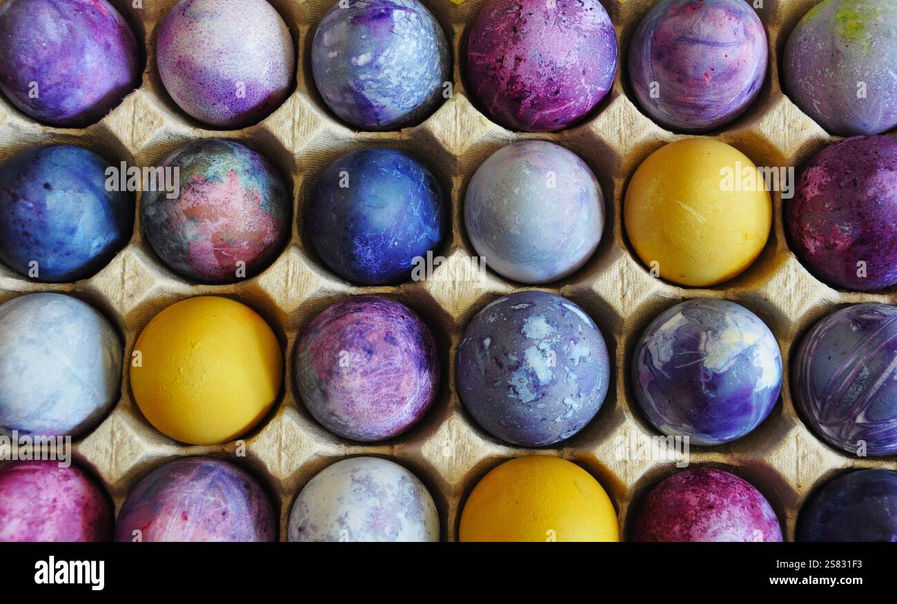 Oeufs de Pâques. Organisé dans un plateau d'oeufs en carton. Coloré, lumineux, fait main, décoré. Emballage en carton durable Banque D'Images