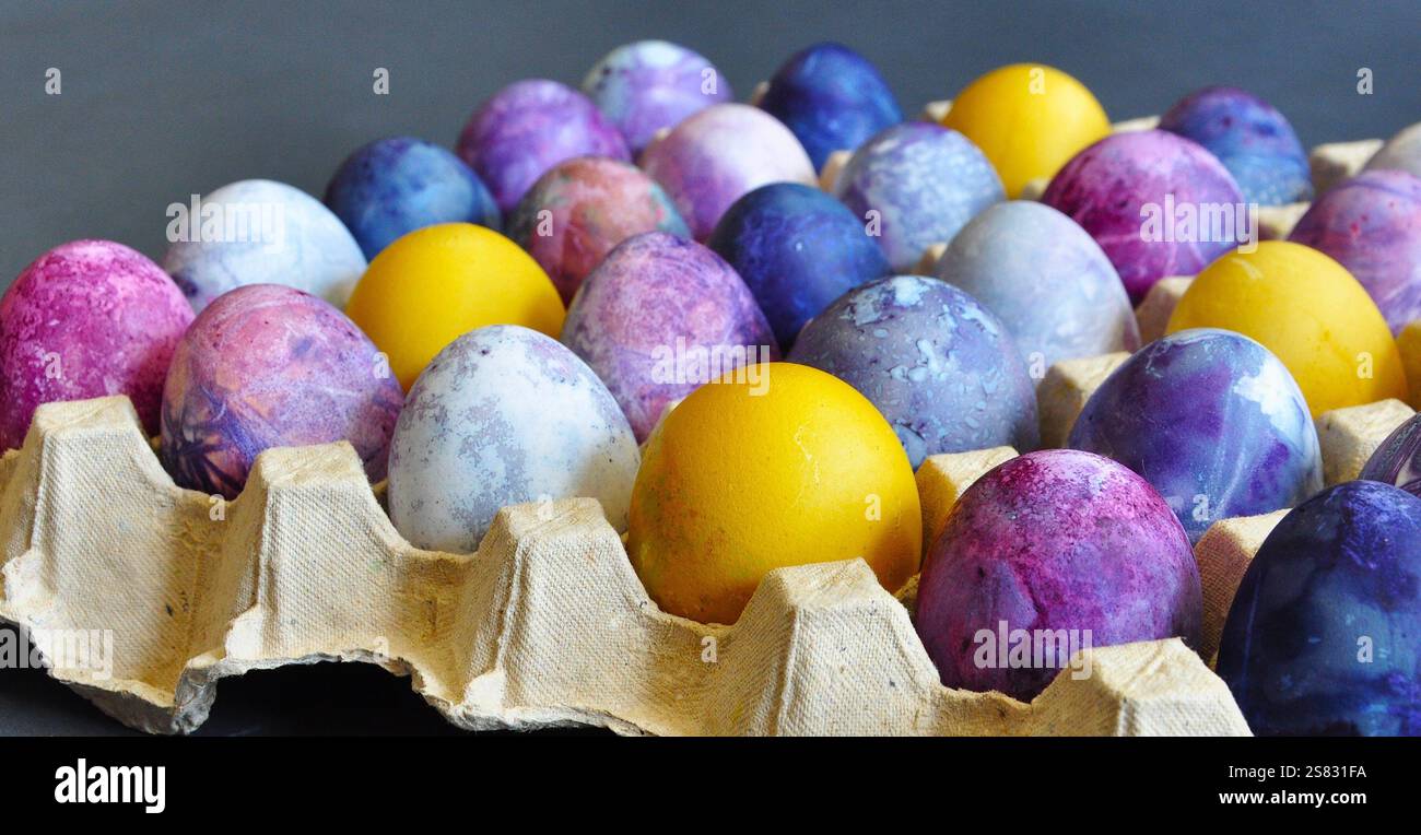 Oeufs de Pâques. Organisé dans un plateau d'oeufs en carton. Coloré, lumineux, fait main, décoré. Emballage en carton durable Banque D'Images