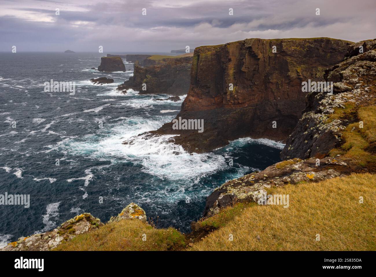 Une tempête sur les falaises volcaniques d'Eshaness, Shetland, en Écosse, crée des vagues massives et des mers turbulentes autour des piles de mer. Banque D'Images