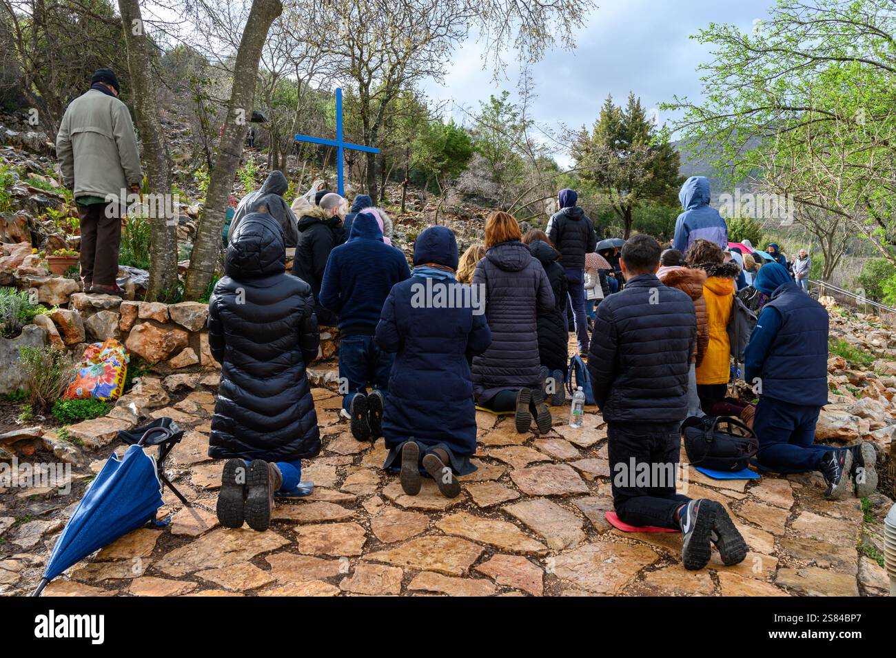 Les gens prient à la Croix bleue [l’un des lieux d’apparitions] au pied du mont Podbrdo à Medjugorje comme d’habitude le 2 du mois. Banque D'Images