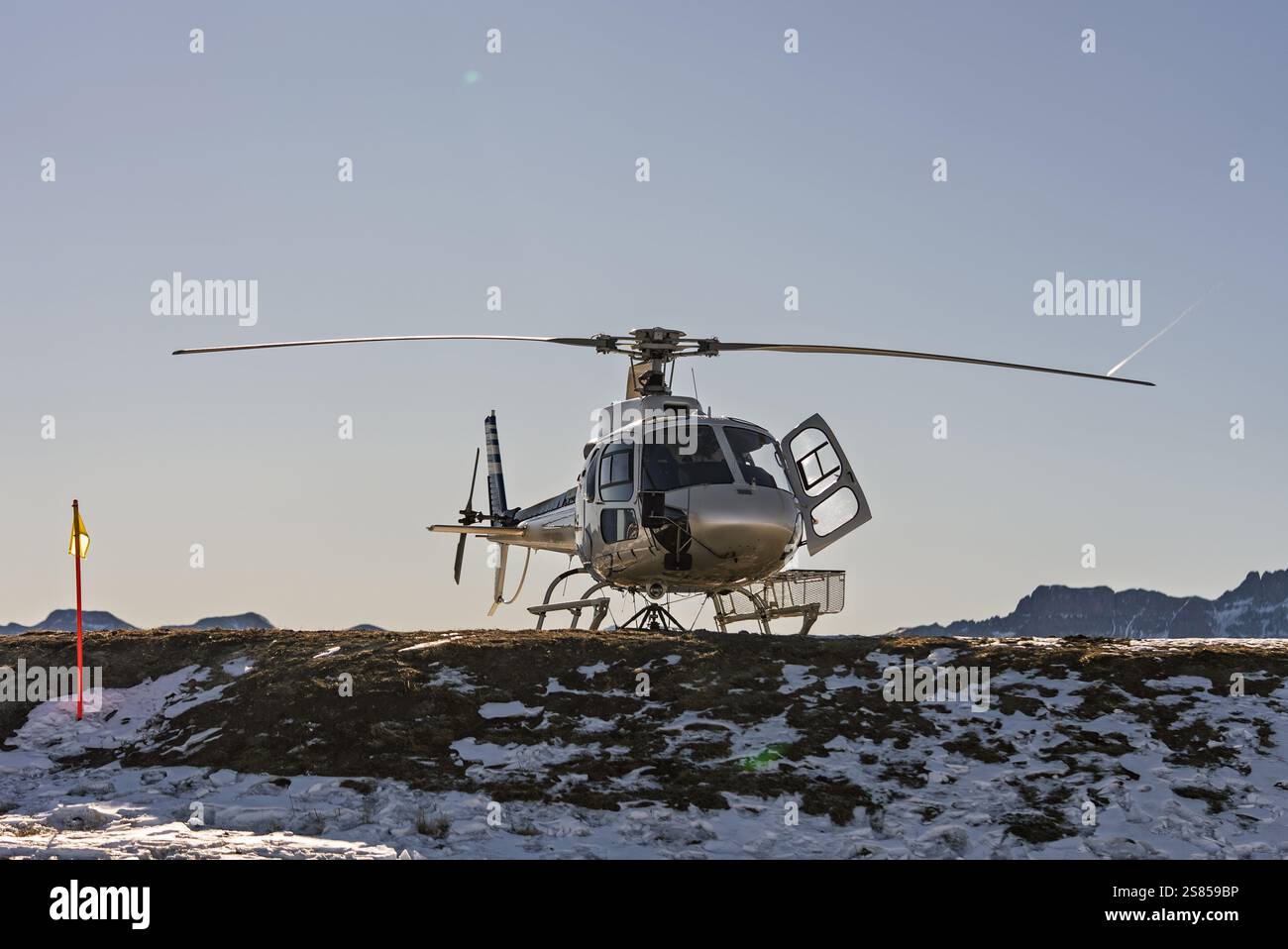 Hélicoptère sur un héliport de montagne enneigé avec un cadre alpin pittoresque. Hélicoptère, vols touristiques au-dessus des Dolomites et des Alpes. L'hélicoptère est Banque D'Images