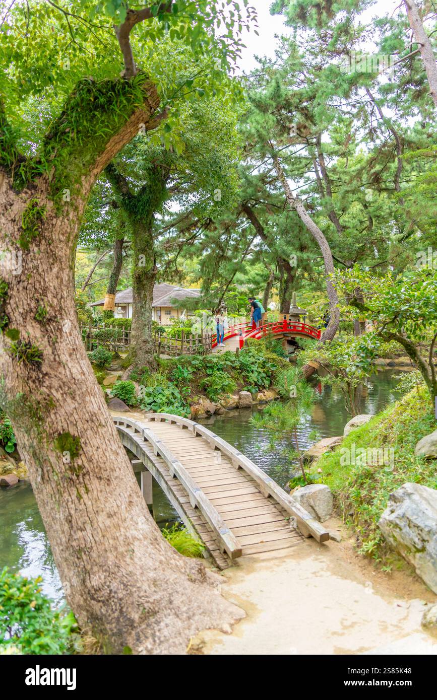 Vue de la passerelle rouge au-dessus de l'étang Takueichi dans le jardin Shukkeien, Kaminoboricho, Naka Ward, Hiroshima, Honshu, Japon Banque D'Images